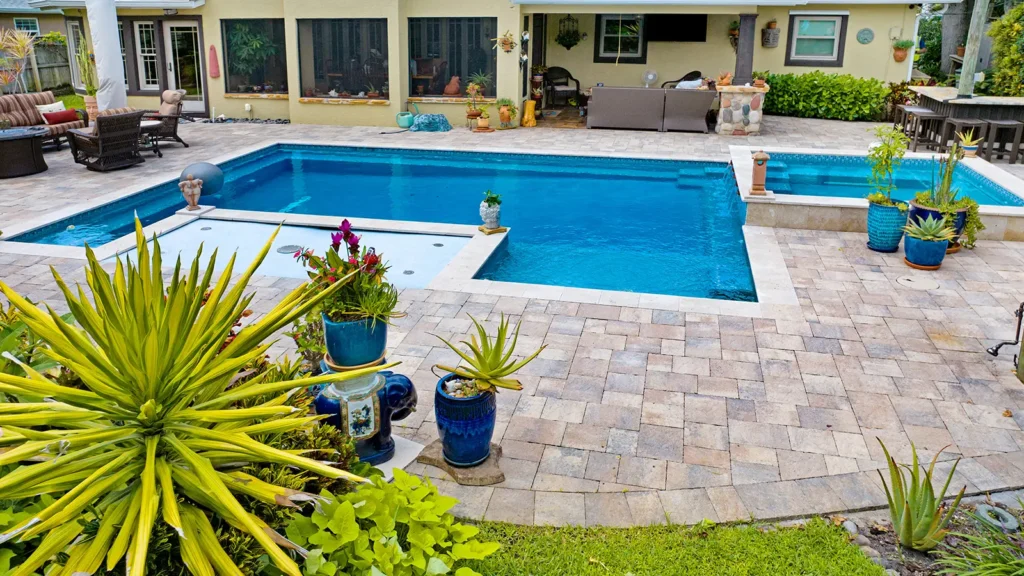 A home backyard with a swimming pool surrounded by tropical plants