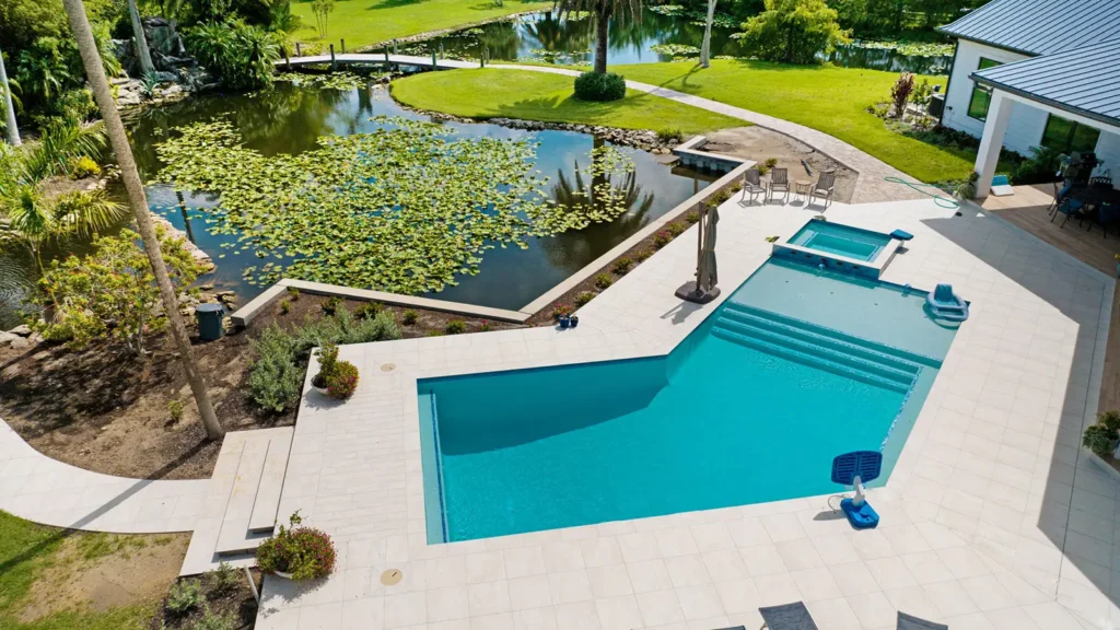 A beautiful backyard with a custom swimming pool and pond