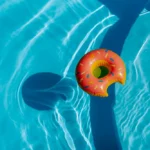 A raft in the shape of a donut floating in a swimming pool