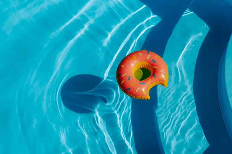 A raft in the shape of a donut floating in a swimming pool