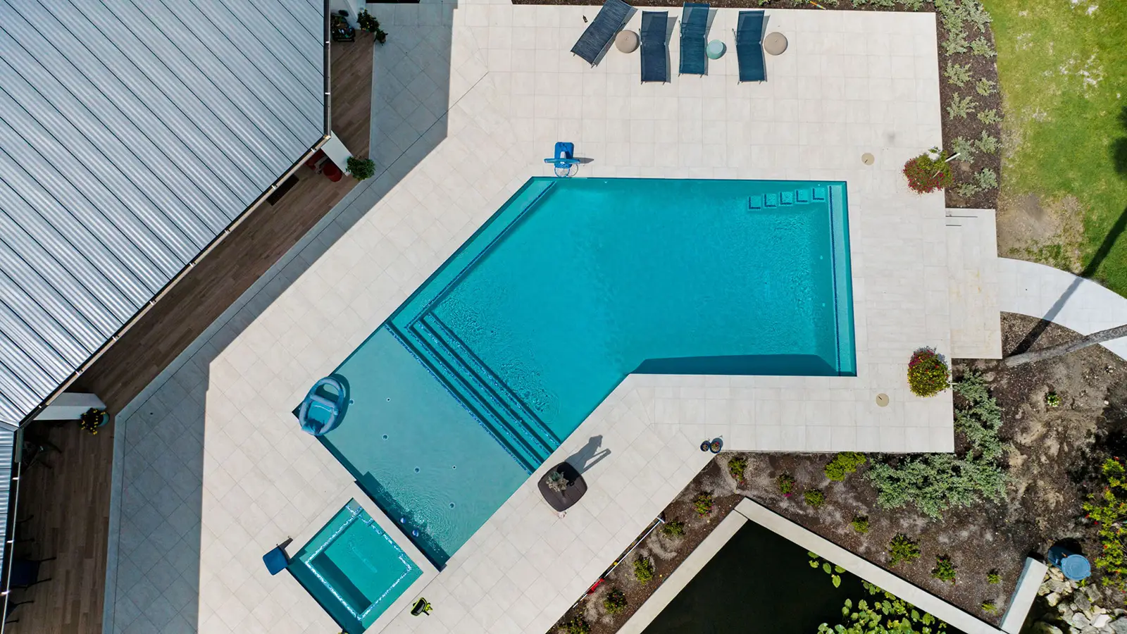 A modern home with patio pavers and a swimming pool