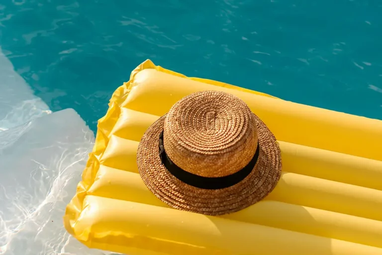 A raft in a pool with a sun hat sitting on top of it