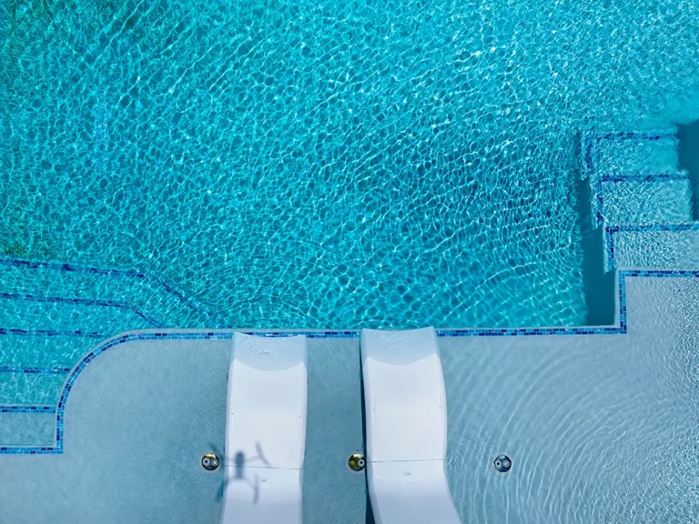 A beautiful swimming pool with custom lounge chairs