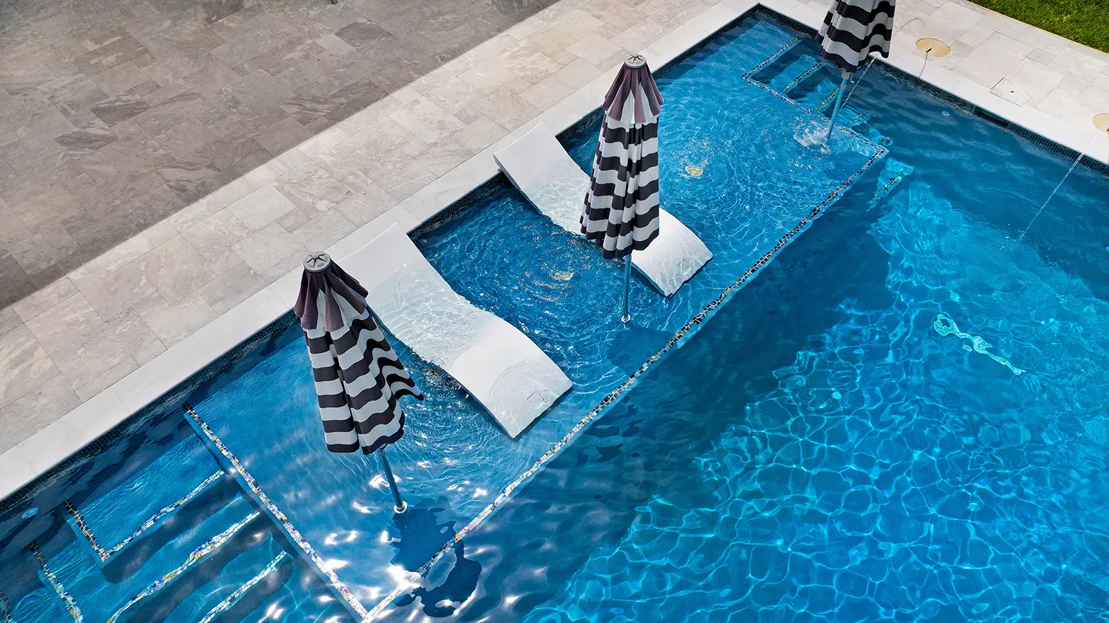 A swimming pool with built in lounge chairs