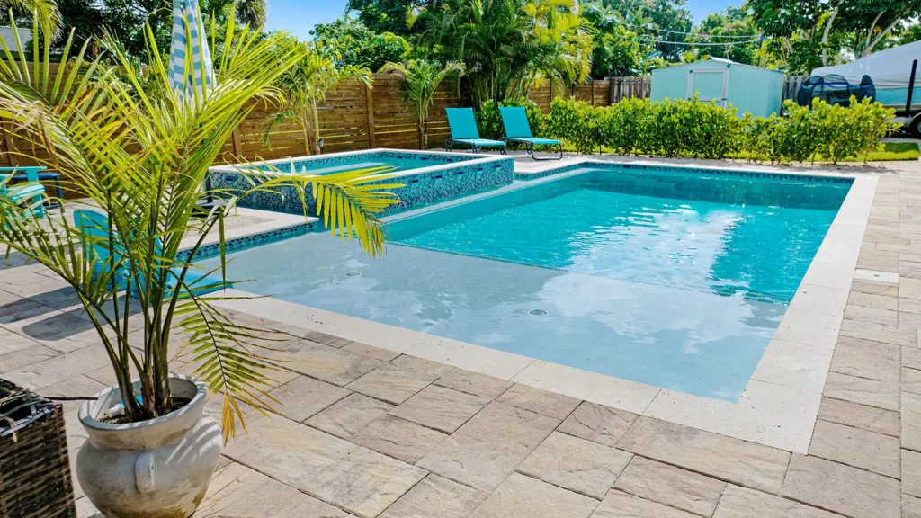 A backyard pool surrounded by tropical landscaping